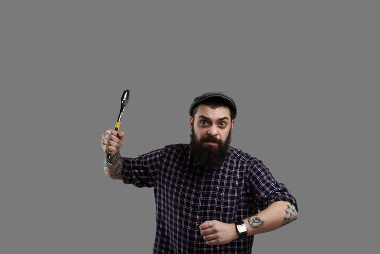 Free Photo dangerous beard hipster with tattooed hands and wrench. crazy man run into the camera with aggressive face. scare concept.