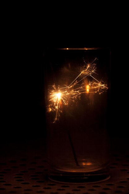 Dark background with glass and sparkler