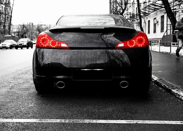 Dark black fast sports car on street background