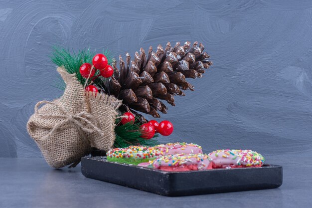 A dark board full of donuts with sweet jelly candies