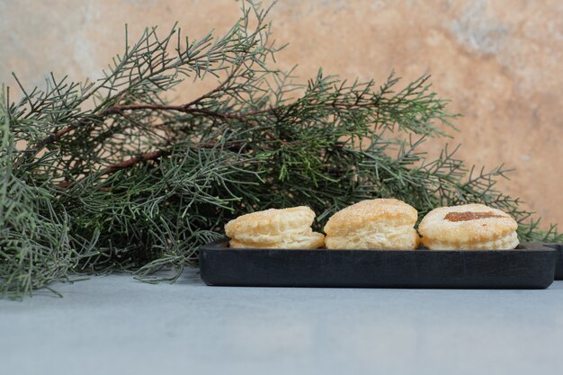 A dark board full of sweet fresh round cookies