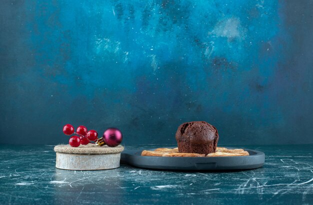 A dark board with chocolate muffin and cookies. High quality photo