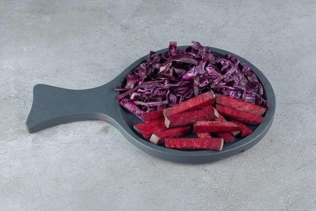 A dark board with sliced cabbage and beetroot. High quality photo