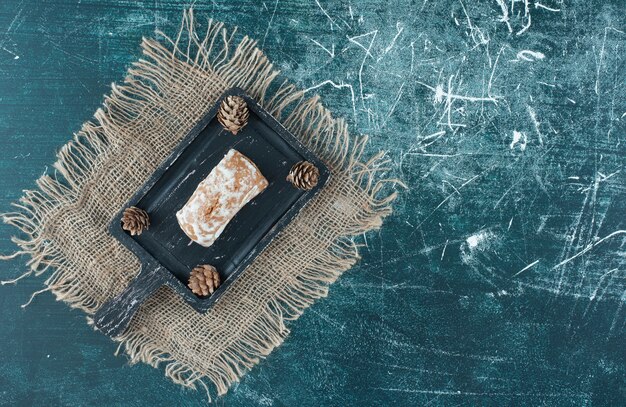 A dark board with tasty gingerbread and pinecones. High quality photo