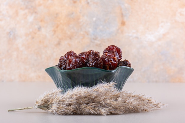 Free photo dark bowl of organic dry dates on white table. high quality photo