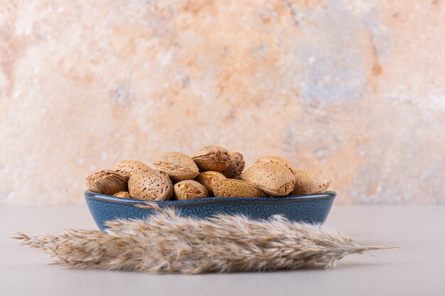 Dark bowl of shelled organic almonds on white background. High quality photo