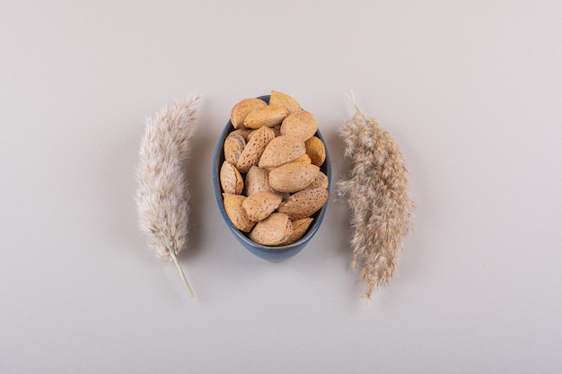 Dark bowl of shelled organic almonds on white background. High quality photo