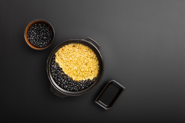 Dark bowls with rice and beans on a dark background