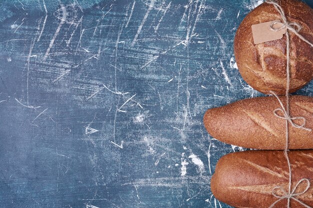 Dark bread buns on wooden board.