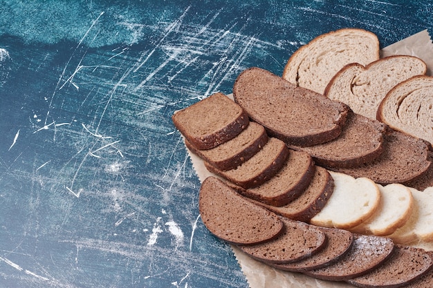 Foto gratuita fette di pane scuro sull'azzurro.