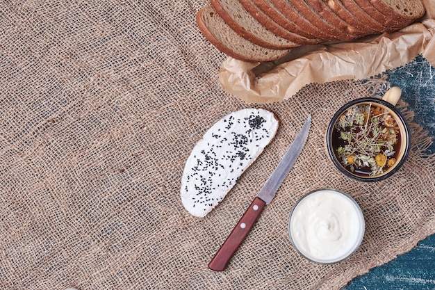 Dark bread slices with a cup of vegetable soup.