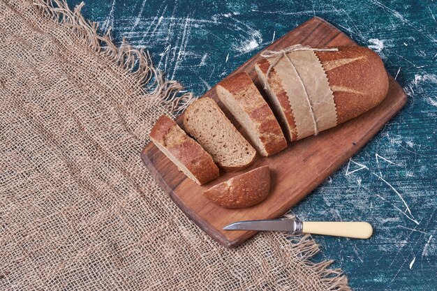 Dark bread slices on wooden board.