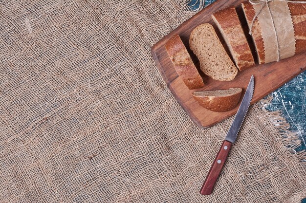 Dark bread slices on wooden board.