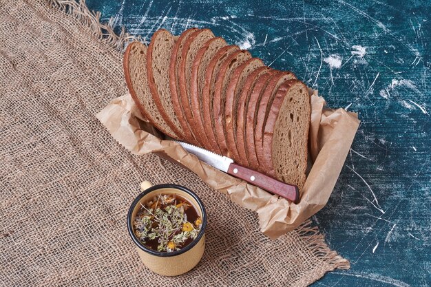 Dark bread in a wooden tray with drink.