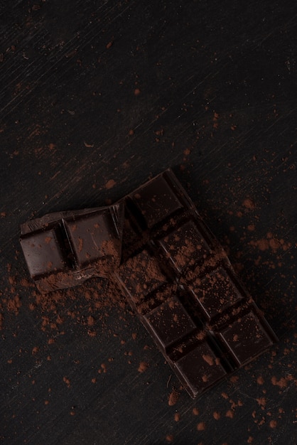 Бесплатное фото Плитка темного шоколада, покрытая шоколадной пудрой