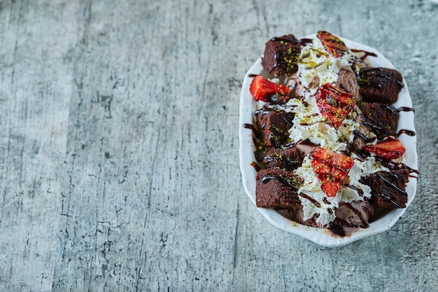 Gelato al cioccolato fondente con fragole sul piatto bianco