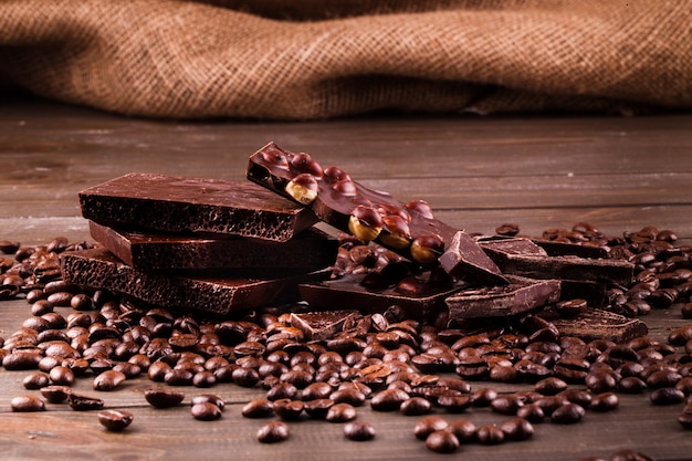 Free photo dark chocolate lies on coffee beans