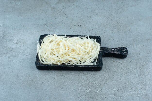 A dark cutting board full of cheese on blue background. High quality photo