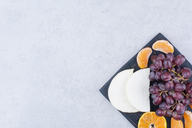 슬라이스 치즈와 과일과 함께 어두운 커팅 보드. 고품질 사진