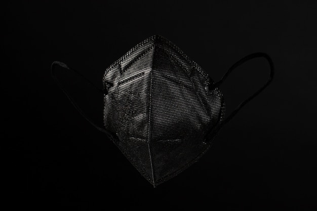 Темная маска ffp2 с темным фоном натюрморт