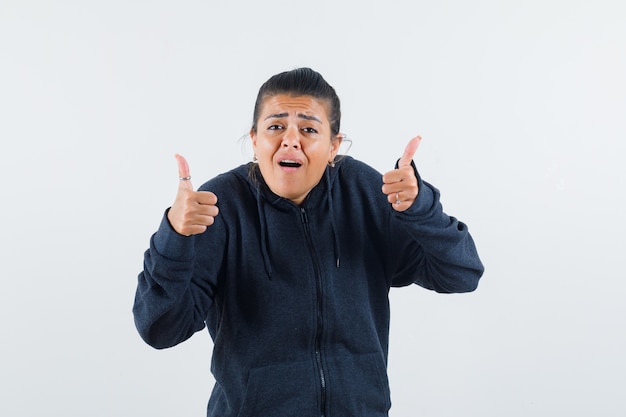 Free photo dark-haired woman in jacket showing thumb up