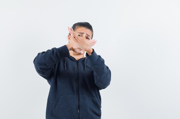 Dark-haired woman showing closed gesture in jacket 