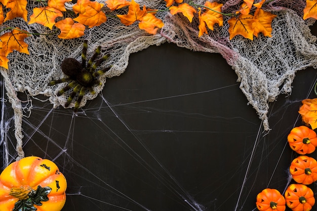 Dark halloween background with pumpkins and spider