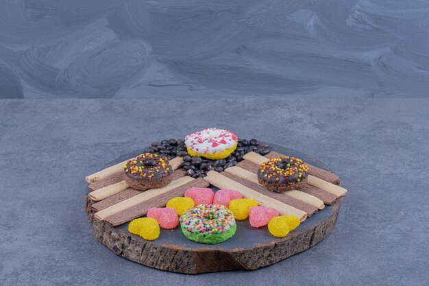 Free photo a dark plate full of donuts and heart shaped jelly candies