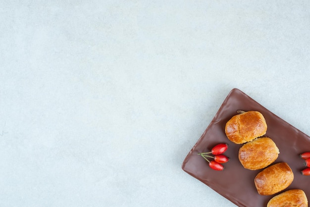 A dark plate of sweet delicious cookies with rosehips.