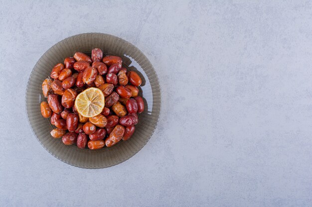 Dark plate of tasty ripe silverberries on stone table. 