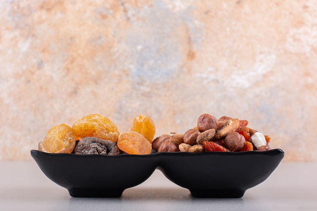 Dark plate of various organic nuts on white background. high quality photo