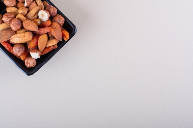 Dark plate of various organic nuts on white background. High quality photo