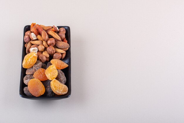 Dark plate of various organic nuts on white background. High quality photo