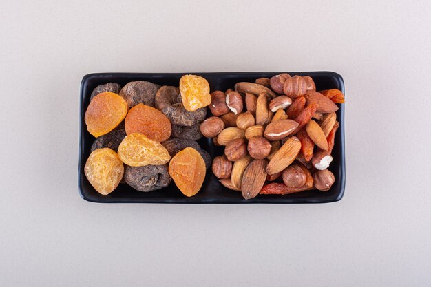 Dark plate of various organic nuts on white background. High quality photo