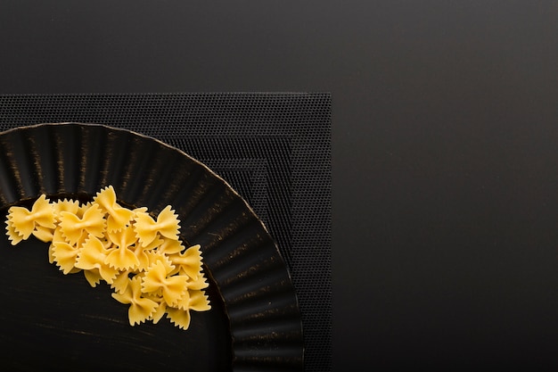 Dark plate with pasta on a dark cloth