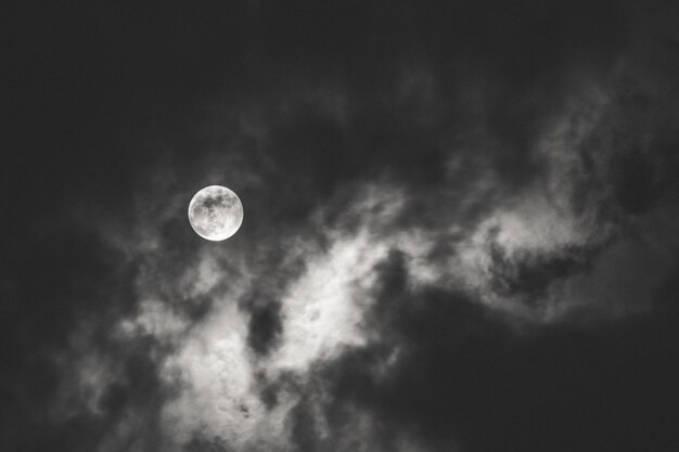 밤 동안 구름 뒤에 빛을 확산 보름달의 어두운 샷