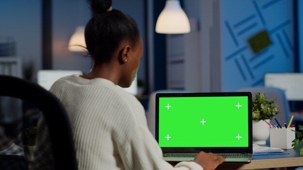 dark skin freelancer working in front of greenscreen display