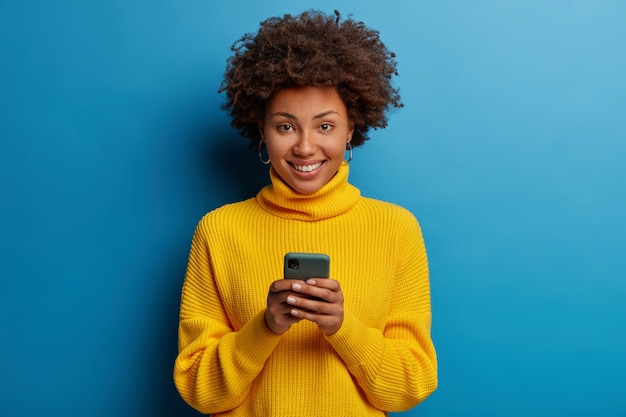 dark skinned lady enjoys distant communication, uses mobile phone