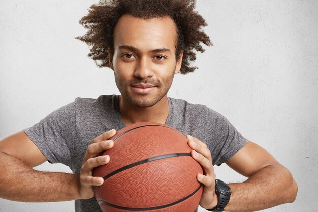 Темнокожий мужчина смешанной расы рекламирует баскетбол