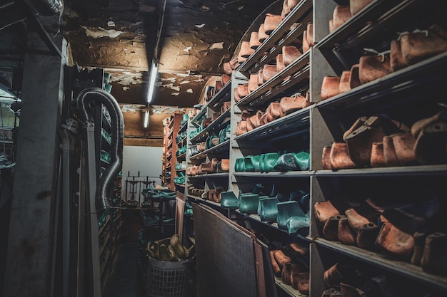 Free photo dark storage with shelves and many forms for creating different shoes and boots.