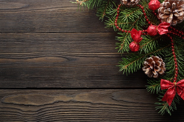 Free photo dark wood table with pine branch and a pine cone