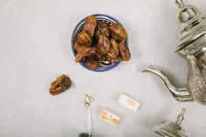 Free photo dates fruit in bowl with turkish delight and teapot