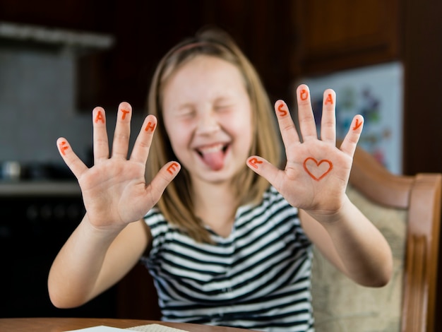 Daughter drawing heart on her hand for father's day