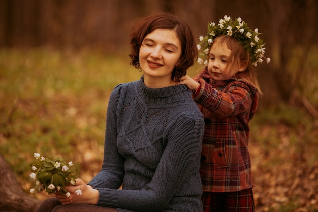 Foto gratuita la figlia che abbraccia sua madre nel parco