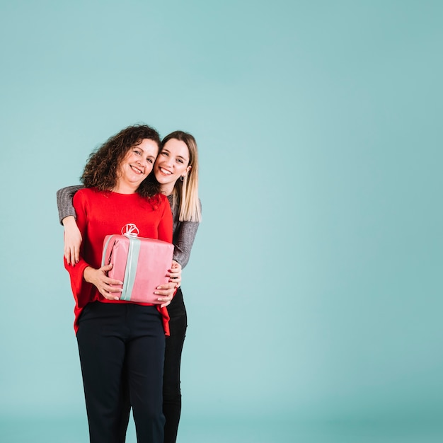 Foto gratuita figlia che abbraccia madre con regalo