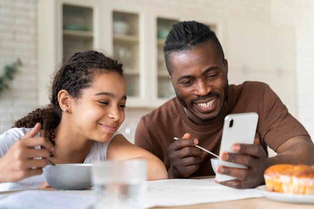 Daughter and father looking at a video on the phone