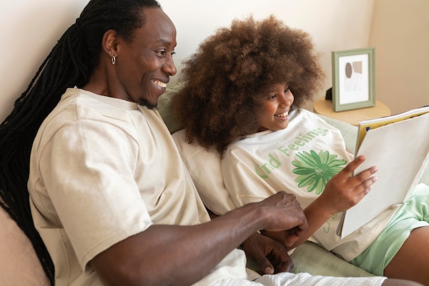 Daughter and father reading a book together