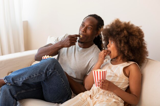 Daughter and father relaxing at home watching movies