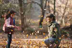 Free photo daughter and father throwing leaves