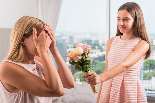 Free photo daughter giving flowers bouquet to mother